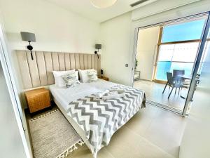 a bedroom with a large bed and a balcony at Intempo by Holuxe - 176 - 17th floor in Benidorm