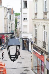 a street with a light hanging from a building at Grand appartement cœur de ville d'Angers - 5 personnes in Angers