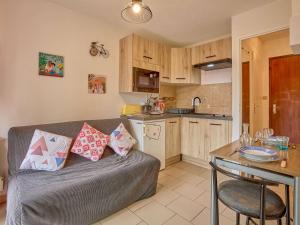 a living room with a couch and a kitchen at Appartement lumineux 2 pers avec animaux admis, parking et WiFi - FR-1-841-26 in Barbotan-les-Thermes +7 photos