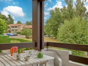 a table on a porch with a view of a yard at Appartement lumineux 2 pers avec animaux admis, parking et WiFi - FR-1-841-26 in Barbotan-les-Thermes