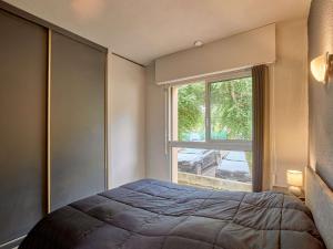 a bedroom with a bed and a large window at Charmant appartement lumineux, terrasse, parking gratuit, animaux admis - FR-1-841-36 in Barbotan-les-Thermes