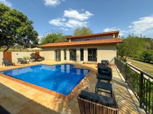 a swimming pool in front of a house at Hotel Fazenda Areia que Canta in Brotas