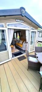 a porch on a boat with a bed and windows at The Humble Bee in Cleethorpes