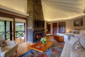 a living room with a bed and a fireplace at Fairmont Mount Kenya Safari Club in Nanyuki