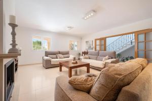 a living room with two couches and a table at Villa Gloria in Cala Pi