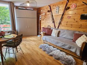 una sala de estar con un sofá y una mesa en Aux pieds des pistes avec balcon - meublé 3 étoiles, en Orcières