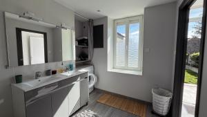 a bathroom with a sink and a mirror and a window at Maison Hémera, une pause en Auvergne in Lapeyrouse +14 photos