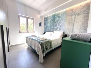 a bedroom with a bed and a painting on the wall at Ostuni BLOOM piscina acqua salata vista mare in Ostuni