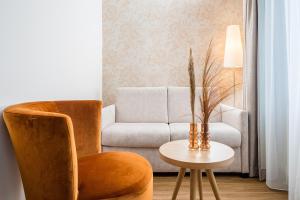 a living room with a couch and a table with a chair at Hotel Flandrischer Hof in Cologne