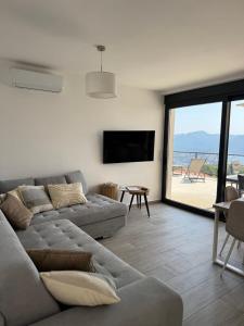 a living room with a couch and a view of the beach at Bay View Village - Villa Eléanore 1 in MitroviÄ‡i