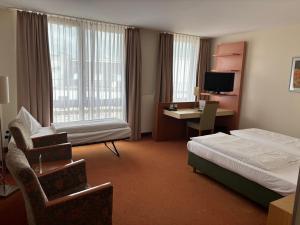 a hotel room with a bedroom with a bed and a desk at Hotel Flandrischer Hof in Cologne