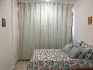 a bedroom with a bed and a window with curtains at CONDOMINIO MAIS MARACANÃ Bl 708 in Rio de Janeiro +6 photos