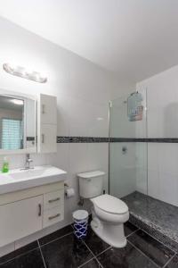 a white bathroom with a toilet and a sink at Casa de Verde Suites at Ocean Park in San Juan