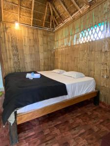 a bedroom with a bed in a straw hut at Adhya HomeStay Hampi Kaddirampura in New Hampi