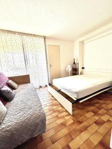 a bedroom with a large bed and a wooden floor at Appartment Cap d'Agde in Cap d'Agde