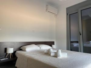 a bedroom with a bed with two towels on it at Aegean Panorama in Paralía Kímis