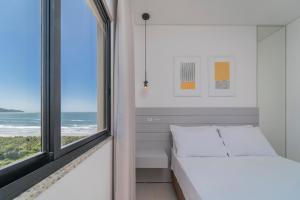 Un dormitorio con una cama y una ventana en HY Apart, en Bombinhas