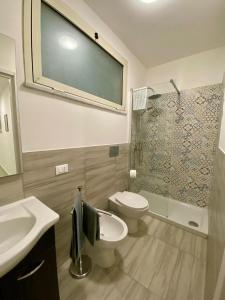 Un baño con inodoro, lavabo y ducha. en Casimiro, en Porticello