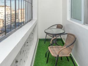 two chairs and a table on a balcony with green grass at Cosy 1 Bedroom in CBD Mombasa with City View in Mombasa