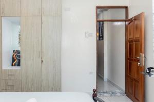 a bedroom with a wooden door and a mirror at Cosy 1 Bedroom in CBD Mombasa with City View in Mombasa +46 photos