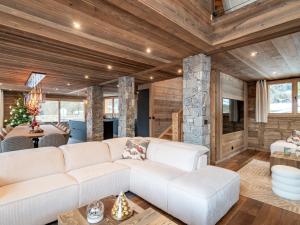 ein Wohnzimmer mit einer weißen Couch und einem Kamin in der Unterkunft Chalet de Luxe aux Gets - 5 Chambres, Jacuzzi, Animaux Acceptés, Parking - FR-1-671-282 in Les Gets