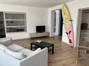 a living room with a surfboard hanging on the wall at Hébergement retour de plage in Tréffiagat