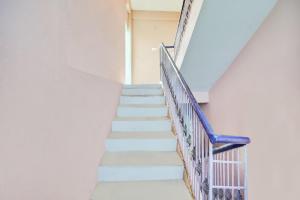 a staircase in a white building with a blue handrail at Hotel O Raunak Food Plaza Family Restaurant & Rooms in Fatwa