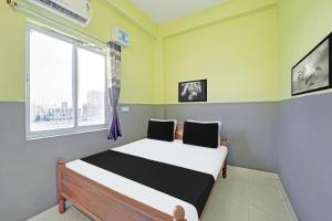 a bedroom with a bed and a window at Hotel O Raunak Food Plaza Family Restaurant & Rooms in Fatwa