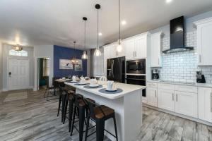 a kitchen with white cabinets and a large table with chairs at Wildlife Themed 4 Bd Pool Home Near Disney in Davenport +32 photos
