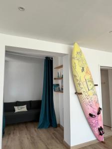a surfboard is hanging on a wall in a room at Hébergement retour de plage in Tréffiagat