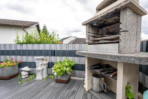 a patio with a pizza oven on a deck at Idyllisches, barrierefreies Ferienhaus in Furth