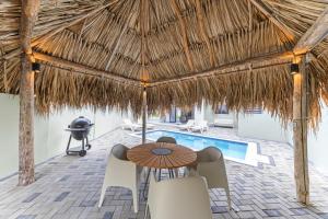 a patio with a table and chairs and a swimming pool at Paradise Villa met privezwembad, Mambo Beach in Willemstad