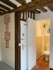 La salle de bains est pourvue d'une porte blanche et de toilettes. dans l'établissement Appartement Des Lingots, à Honfleur