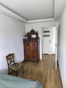 a bedroom with a bed and a chair and a door at Downtown Apartment in Warsaw