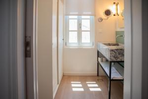 una pequeña cocina con ventana y fregadero en Liberty Suites Spetses, en Spetses 100 fotos más