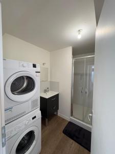 una lavatrice e un'asciugatrice in un bagno con doccia di Appartement Cosy et parking a Vannes