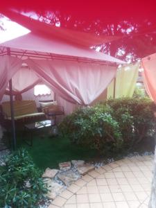 a pink tent with a bench and some plants at Villa Verde Apartments and Rooms in Premantura