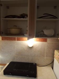 a kitchen counter with a light in a cupboard at Villa Verde Apartments and Rooms in Premantura