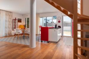 una cucina e un soggiorno con un'isola rossa e un tavolo di Maison à 3min de la plage à pied a Sarzeau