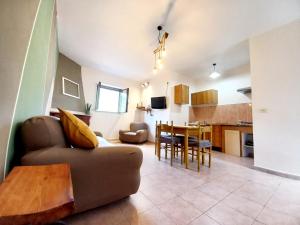 a living room and kitchen with a couch and a table at Zi' Ciccio Casa Vacanze in Corleto Monforte