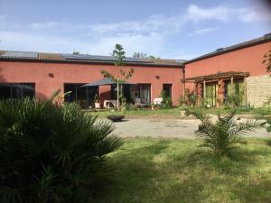 a building with a yard with plants in front of it at L'hacienda in Champagné-les-Marais