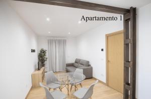 un soggiorno con tavolo, sedie e divano di Apartamentos LA PARRILLA a La Parrilla