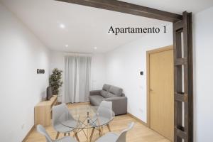 un soggiorno con tavolo e sedie in vetro di Apartamentos LA PARRILLA a La Parrilla