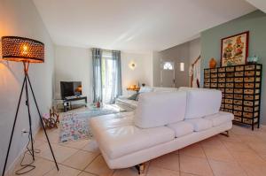 a living room with a white couch and a lamp at Les lys in Saint-Julien-les-Villas