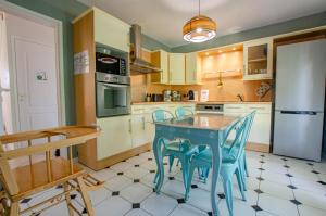 a kitchen with a blue table and chairs at Les lys in Saint-Julien-les-Villas