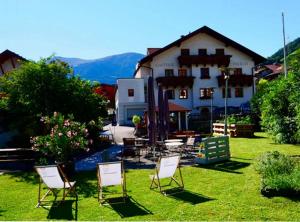 a group of chairs sitting in the grass in front of a building at Gasthof Falkeis in Kauns