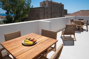 a bowl of fruit on a wooden table on a balcony at Liberty Suites Spetses in Spetses