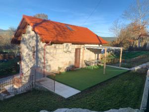 a small house with an orange roof and a yard at CASA TIO HERMINIO in O Irixo