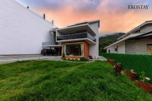a house with a green lawn in front of it at EKOSTAY - Amber Villa in Kodaikānāl