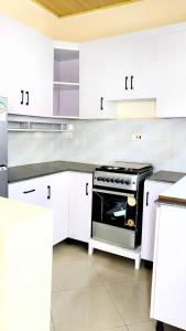 een keuken met witte kasten en een fornuis bij Kigali Beauty Homes in Kigali